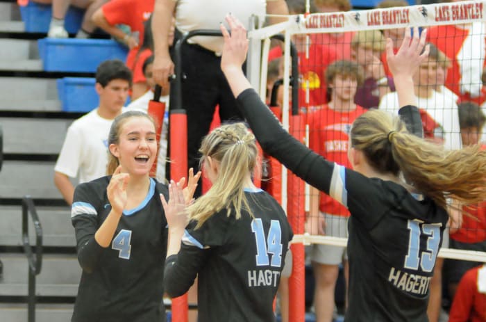 Hagerty's Abby Mas celebrates a kill with teammates Faith Walsh (14) and Jenness Orcutt (13) during their match against Lake Brantley. Mass had seven kills and four aces in the Huskies' victory.